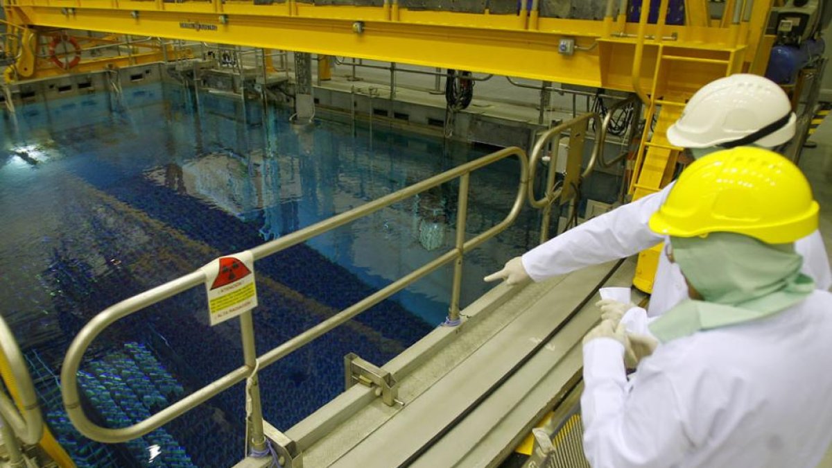 Dos operarios de la central de Garoña supervisan la piscina del reactor que contiene residuos radiactivos.-ISRAEL L. MURILLO