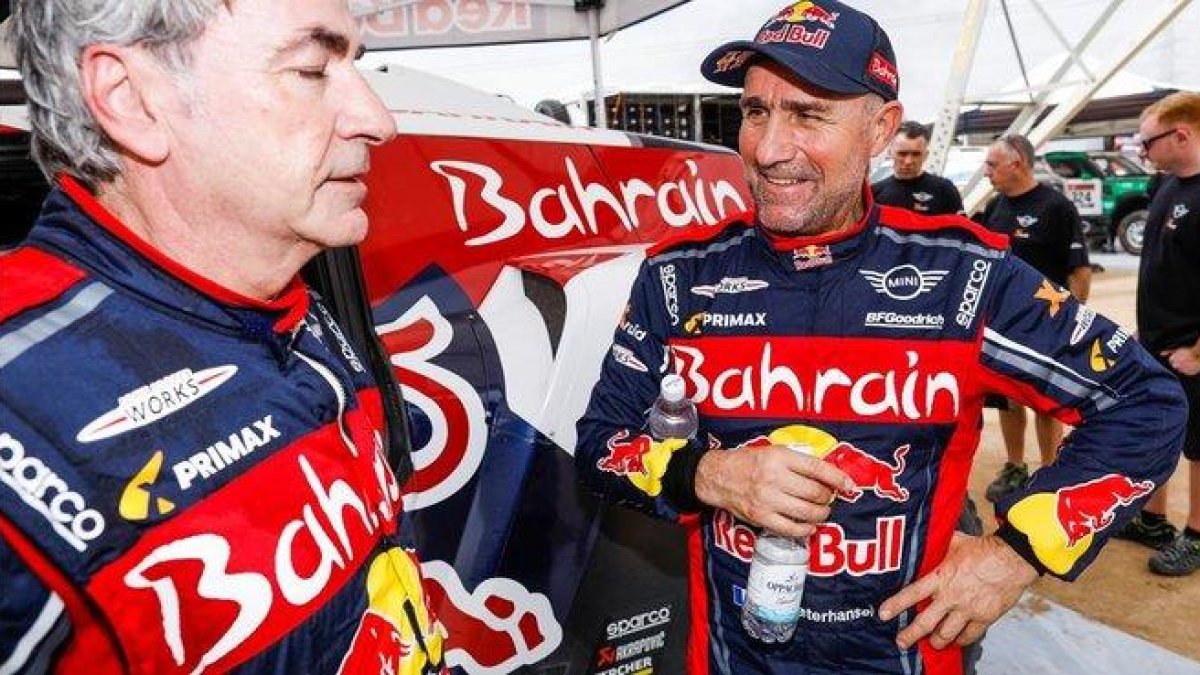 Stephane Peterhansel, a la derecha, habla, feliz, con un agotado Carlos Sainz.-DPPI / FRANCOIS FLAMAND