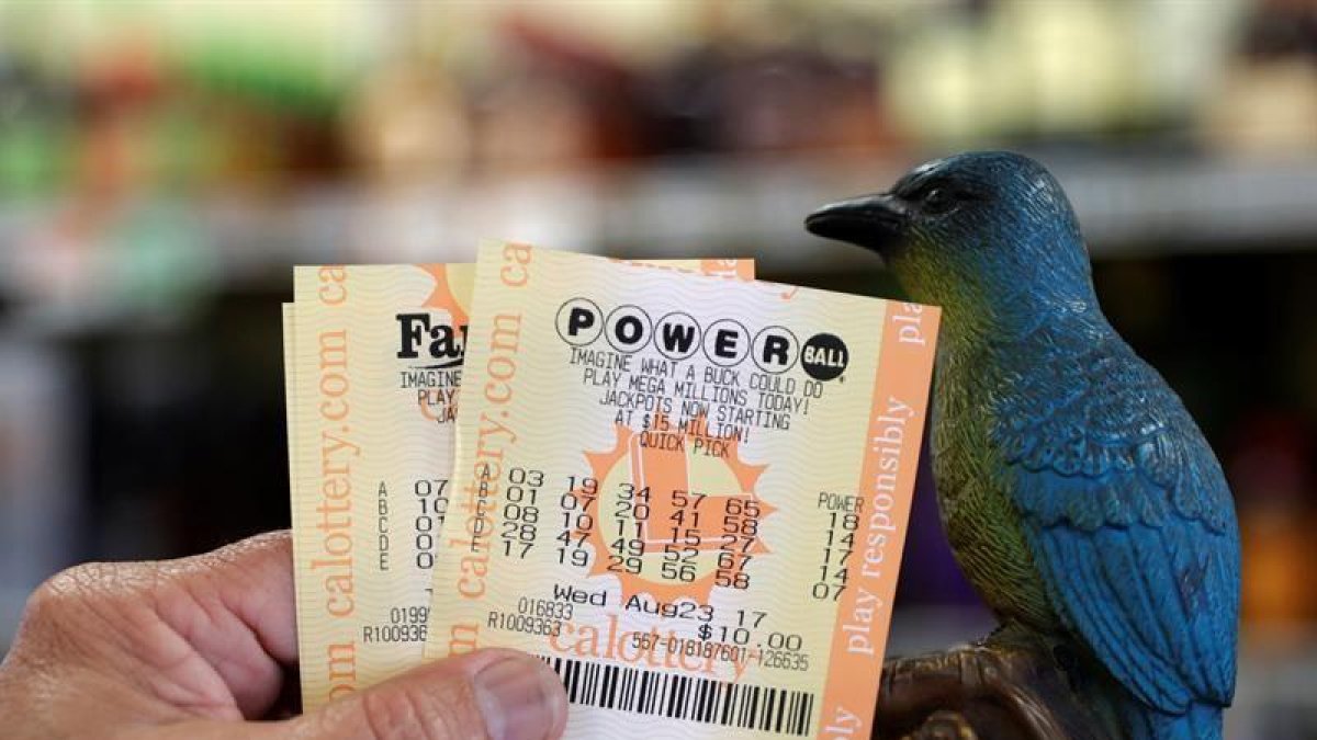 Un hombre muestra sus billetes de lotería Powerball en la tienda de licor Bluebird el 22 de agosto de 2017, en Hawthorne, California (EE.UU.).-EFE