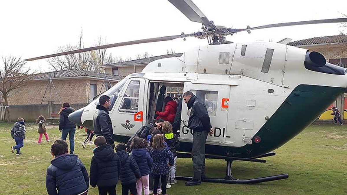 Un grupo de alumnos espera para subir a un helicóptero.-ECB