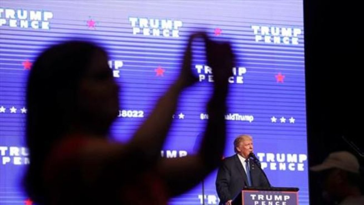 Una electora de Trump se hace una foto para las redes sociales, durante un mitin en Miami.-AFP / JOE RAEDLE
