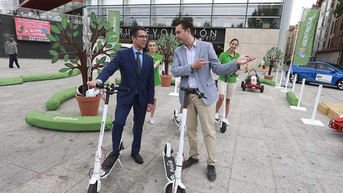 García y De la Rosa junto a los patinetes eléctricos que hay en el Paseo Sierra de Atapuerca.-RAÚL G. OCHOA