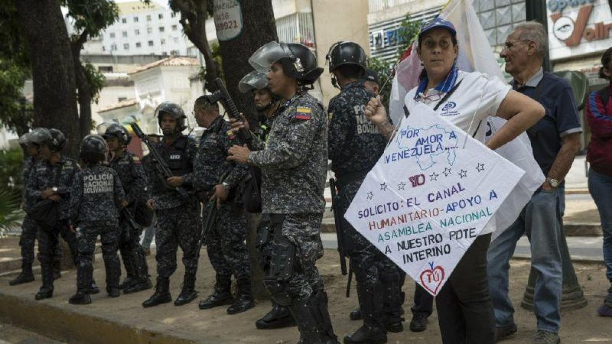 Policías venezolanos vigilan durante las protestas en contra de Nicolás Maduro.-AP