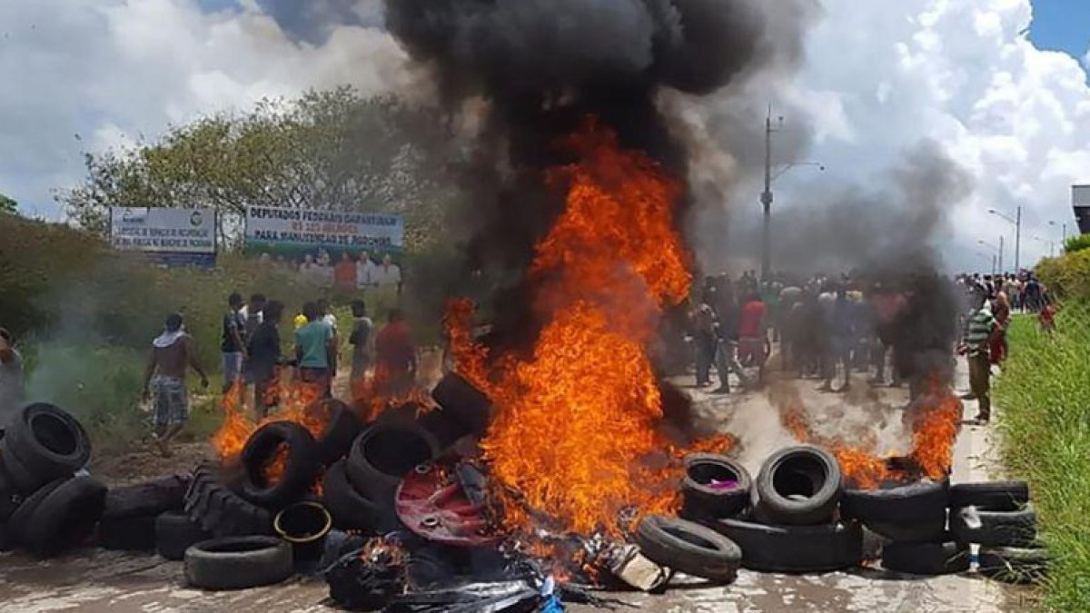 Habitantes de la ciudad brasileña de Pacaraima, en la frontera con Venezuela, incendian neumáticos y pertenencias de inmigrantes venezolanos durante los disturbios registrados el 18 de agosto del 2018.-AFP / ISAC DANTES