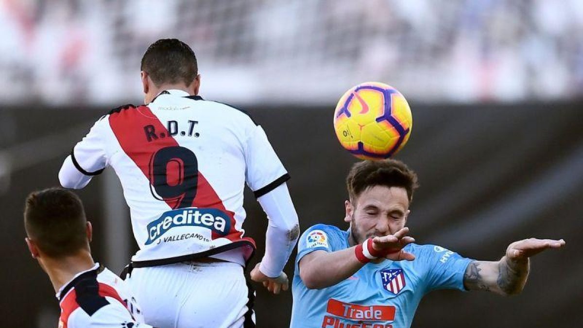 Saúl (d) remata un balón ante la oposición de Raúl De Tomás.-AFP