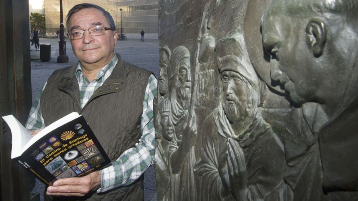 El autor del libro, junto a una representación de peregrinos en la puerta de la iglesia de San Lesmes.-ISRAEL L. MURILLO