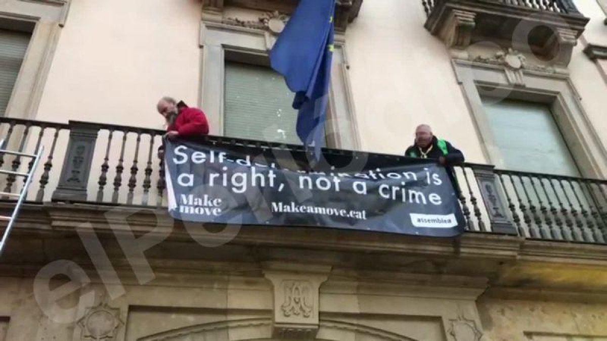 Los manifestantes de la ANC han subido mediante una escalera al balcón de la sede de la Comisión Europea, en Barcelona.-JÚLIA REGUÉ
