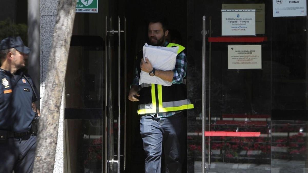 Agentes policiales llevando a cabo un registro.-EFE