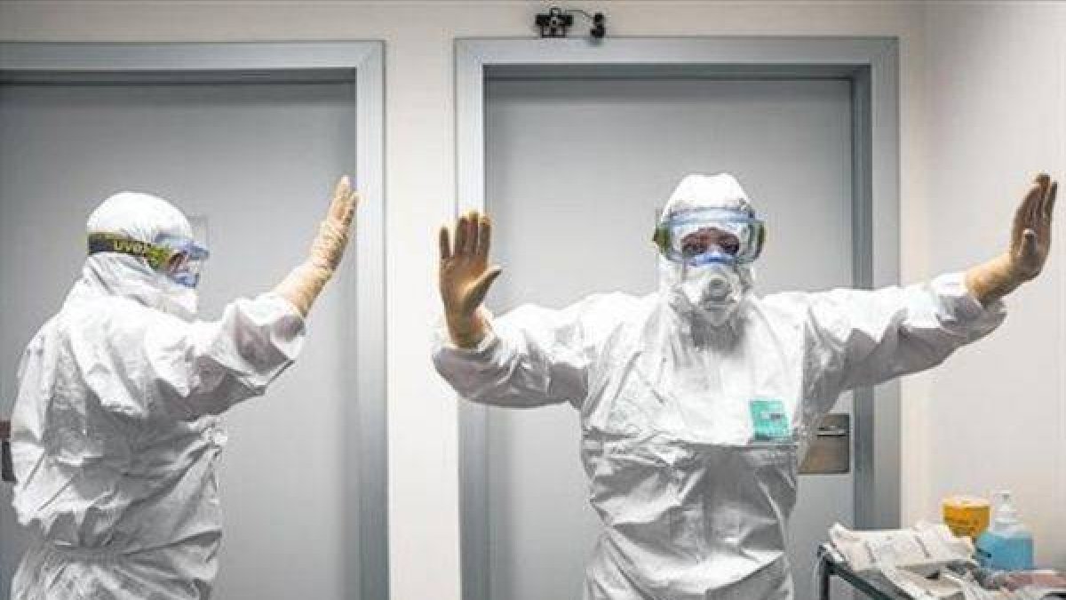 Sanitarios de Valencia reciben indicaciones sobre el modo de colocarse los trajes para tratar el ébola.-Foto: MIGUEL LORENZO