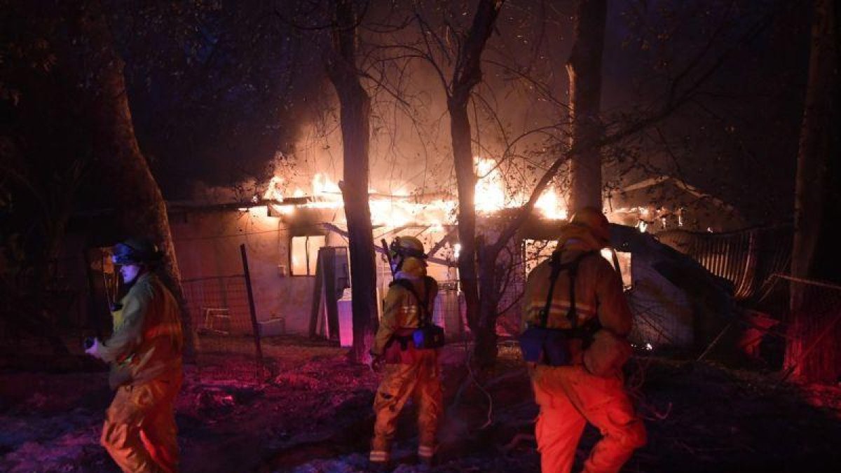 Bomberos en una casa en llamas en el sur de California.-AFP / MARK RALSTON