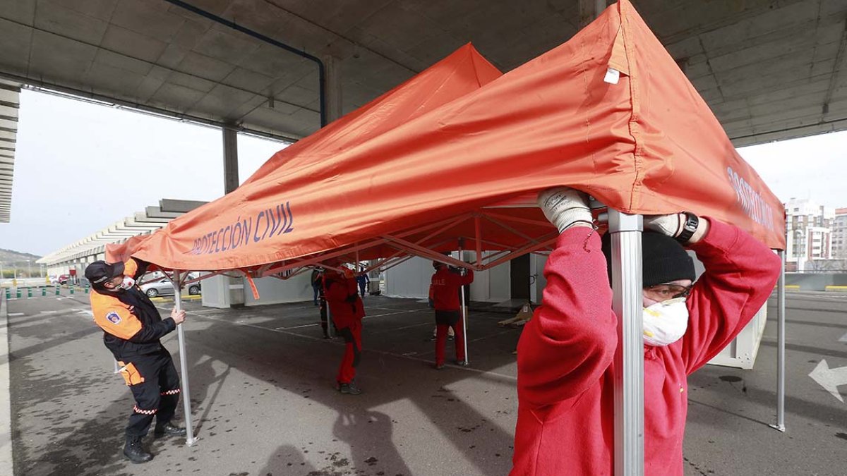 Voluntarios de Protección Civil instalan el primer módulo que se colocará junto a la estructura metálica que se montará para realizar el triaje del Covid-19. RAÚL OCHOA