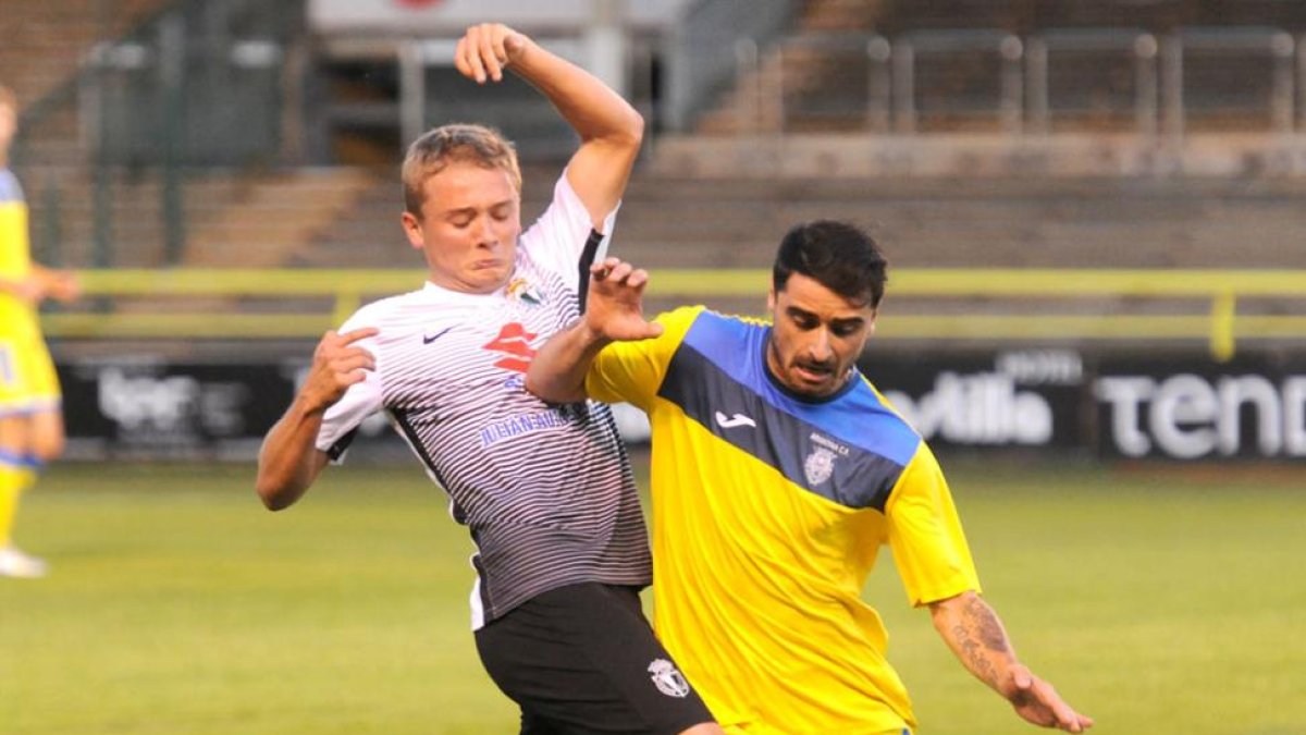 El jugador del Burgos CF Xabi presiona a Zazu en un lance del choque de ayer.-ISRAEL L. MURILLO