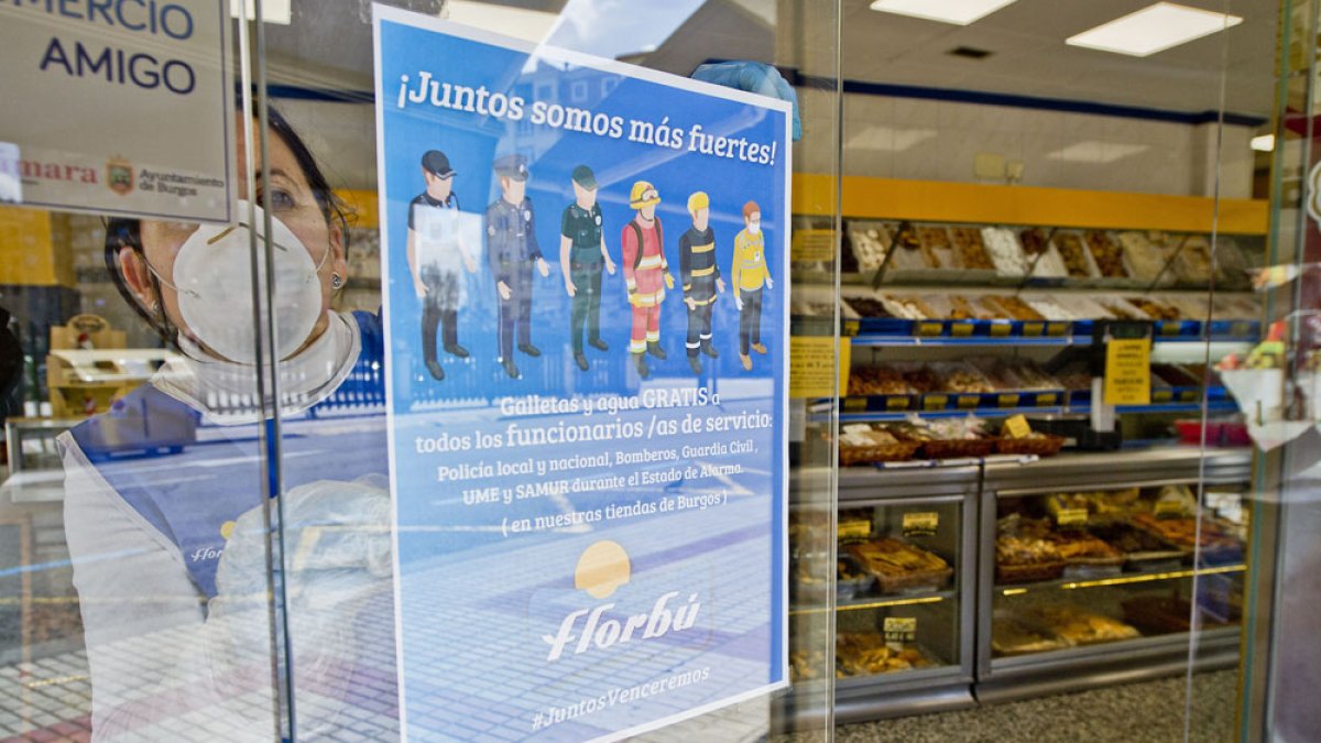 Una dependienta de uno de los establecimientos de Florbú coloca el cartel de la campaña. ISRAEL L. MURILLO