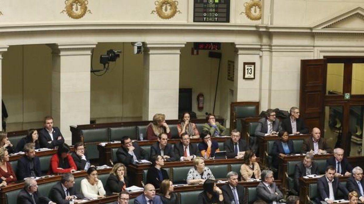 Los parlamentarios belgas, con la imagen de pantalla que publica los resultados de la votación aprobada de la eutanasia para los menores, en febrero del 2014.-JULIEN WARNAND / EFE