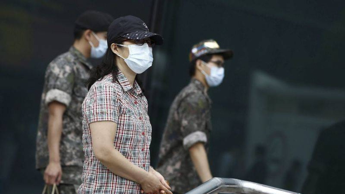 Soldados y civiles pasean con mascarillas por las calles de Seúl.-Foto: EFE