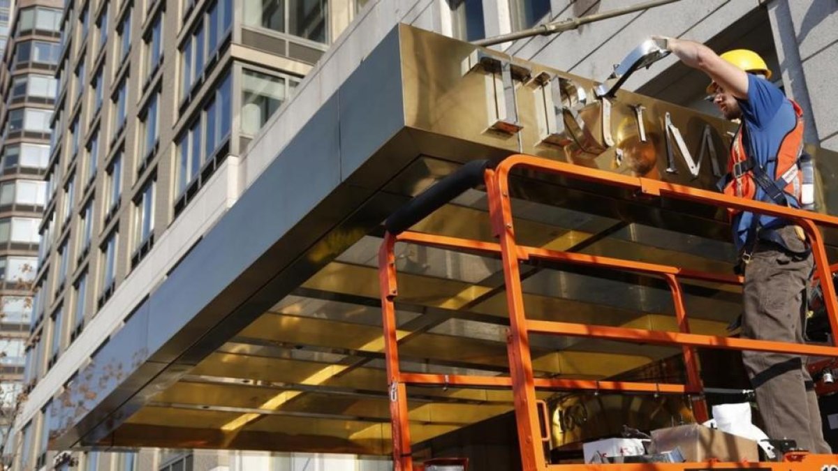 Un operario retira el nombre de la fachada de un edificio de lujo conocido hasta ahora como Trump Place, en Nueva York, el 16 de noviembre.-AP