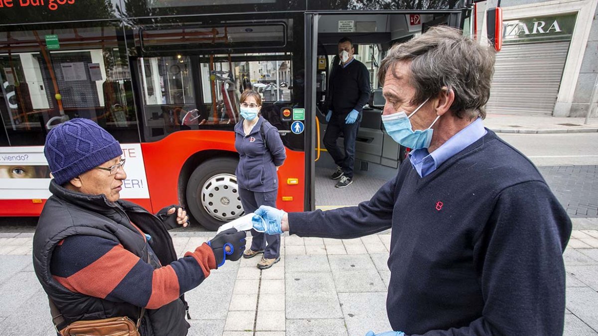 Un empleado de Autobuses entrega una mascarilla a una viajera el día en que empezaron a ser obligatorias para montar en el transporte público. SANTI OTERO