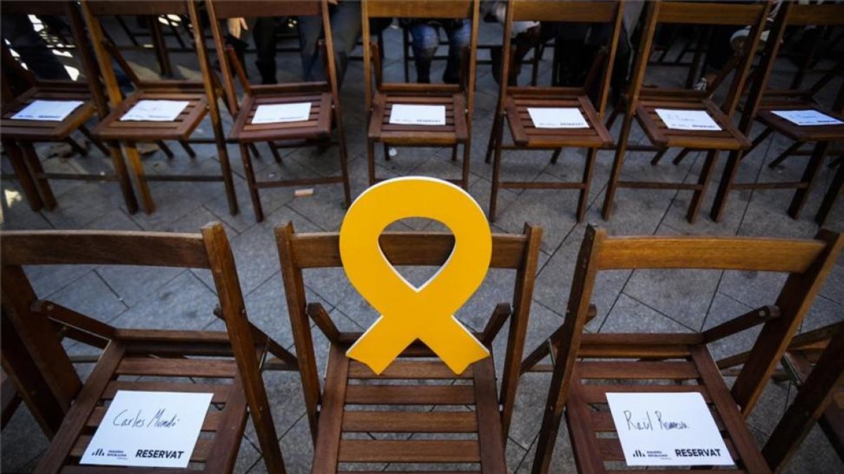 Silla vacía con un lazo amarillo en un mitin de ERC.-DANNY CAMINAL