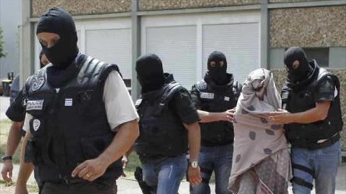 Las fuerzas de seguridad se llevan detenida a la mujer del terrorista.-Foto: REUTERS/EMMANUEL FOUDROT