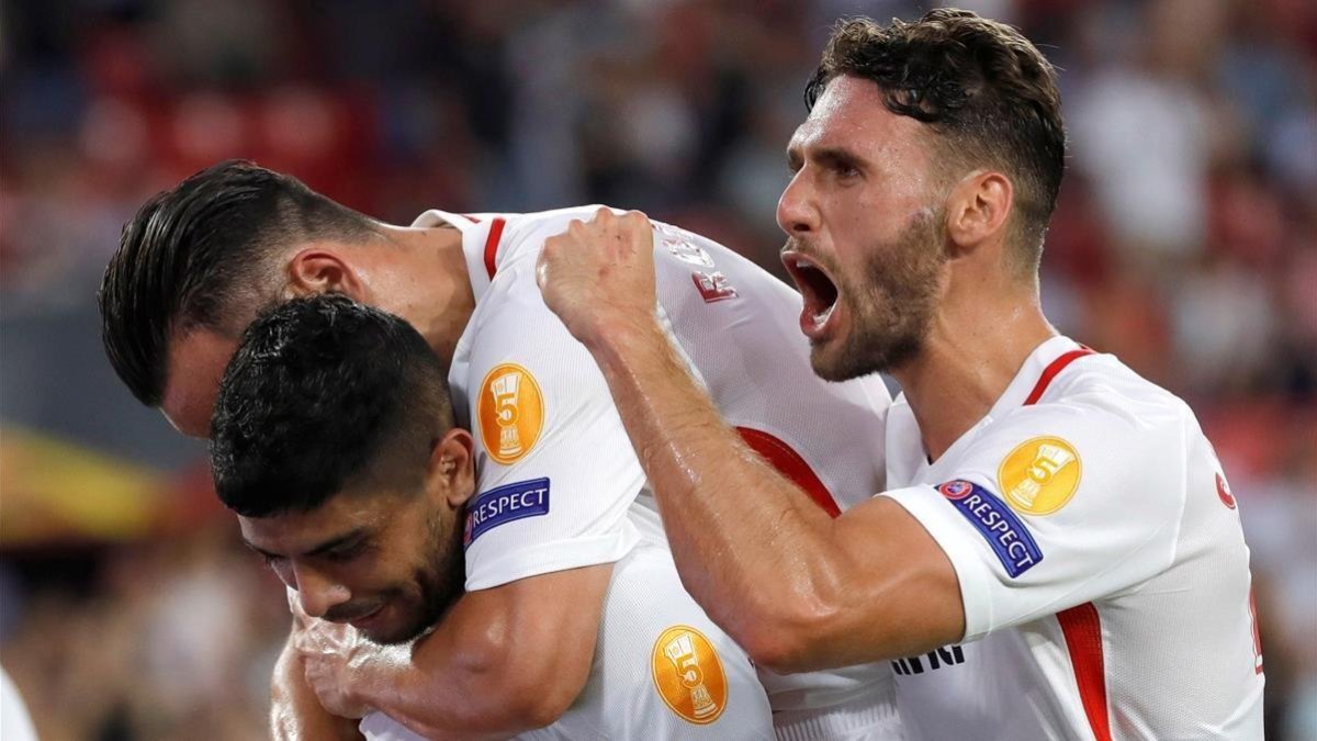 Banega, Roque Mesa y Sergi Gómez celebran uno de los goles del Sevilla.-EFE / JULIO MUÑOZ