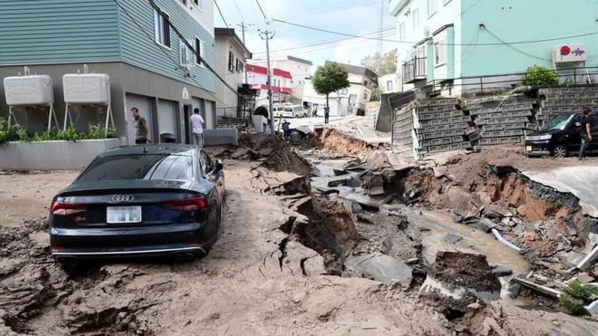 Un vehiculo permanece atrapado entre el lodo en una calle destruida tras el fuerte terremoto.-EFE
