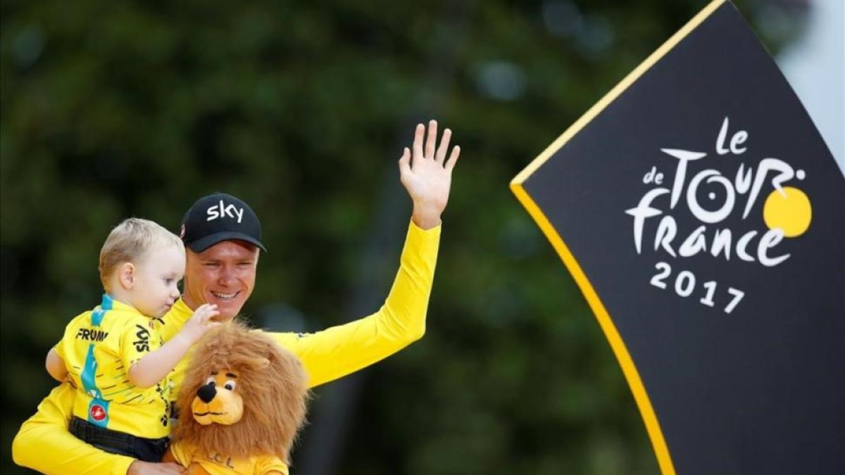 Chris Froome con su hijo, en el podio de París.-REUTERS / CHRISTIAN HARTMANN