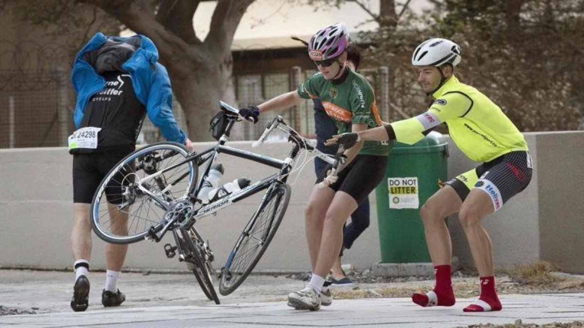 Ciclistas luchan contra el fuerte viento para que sus bicicletas no salgan volando.-AFP / RODGER BOSCH