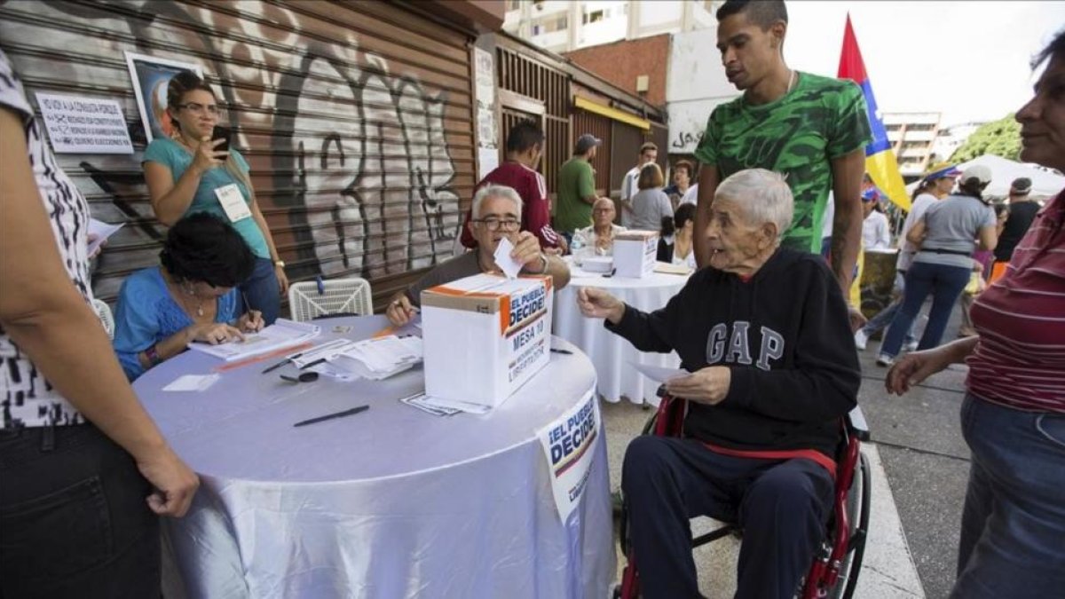 Un grupo de personas participa en la votación de la oposición en Caracas.-EFE / NATHALIE SAYAGO