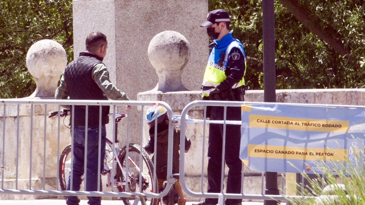 Un agente de la Policía Local conversa con un ciudadano en el puente de San Pablo. ISRAEL L. MURILLO