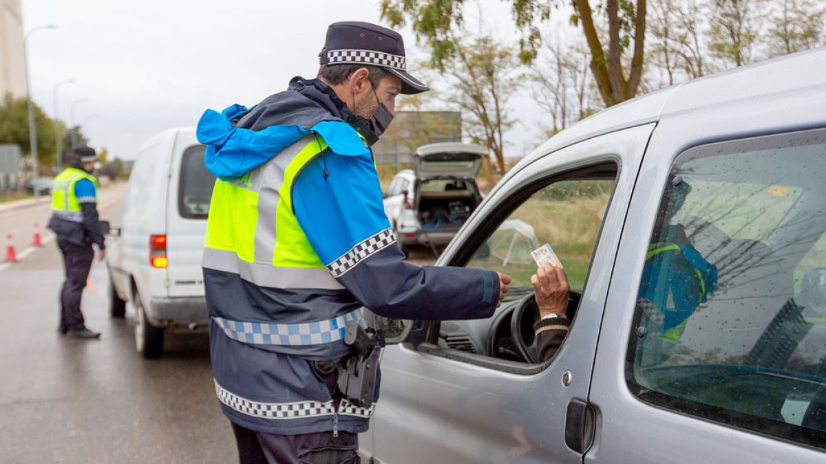 Dos agentes de la Policía Local de Aranda piden la documentación a los ocupantes de dos vehículos ayer en Aranda, el primer día del nuevo confinamiento. PACO SANTAMARÍA