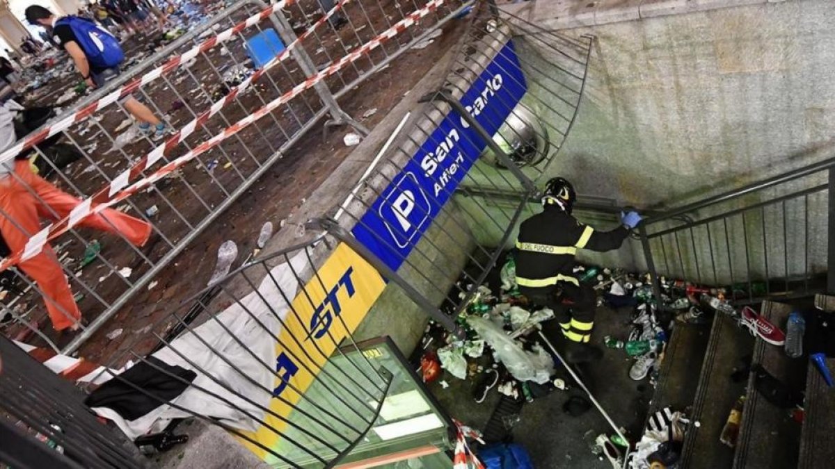 Un bombero inspecciona una valla que cedió en la plaza de San Carlos de Turín, probable origen de la estampida.-AP / ALESSANDRO DI MARCO