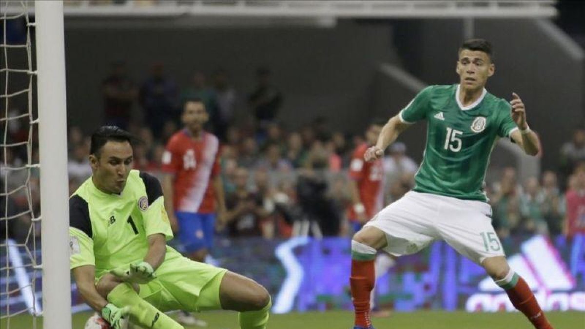 Keylor Navas ayuda a introducir en su portería el balón rematado por el mexicano Araujo.-AP / REBECCA BLACKWELL