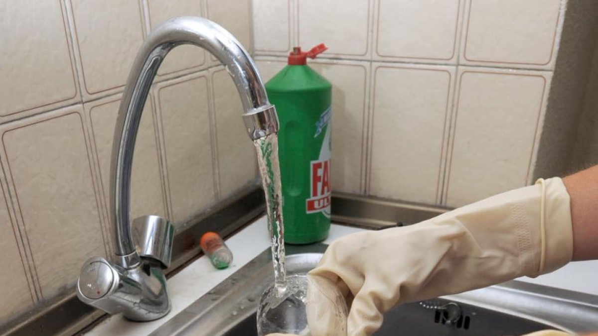 Una persona friega los cacharros en la cocina de su vivienda.-ISRAEL L. MURILLO
