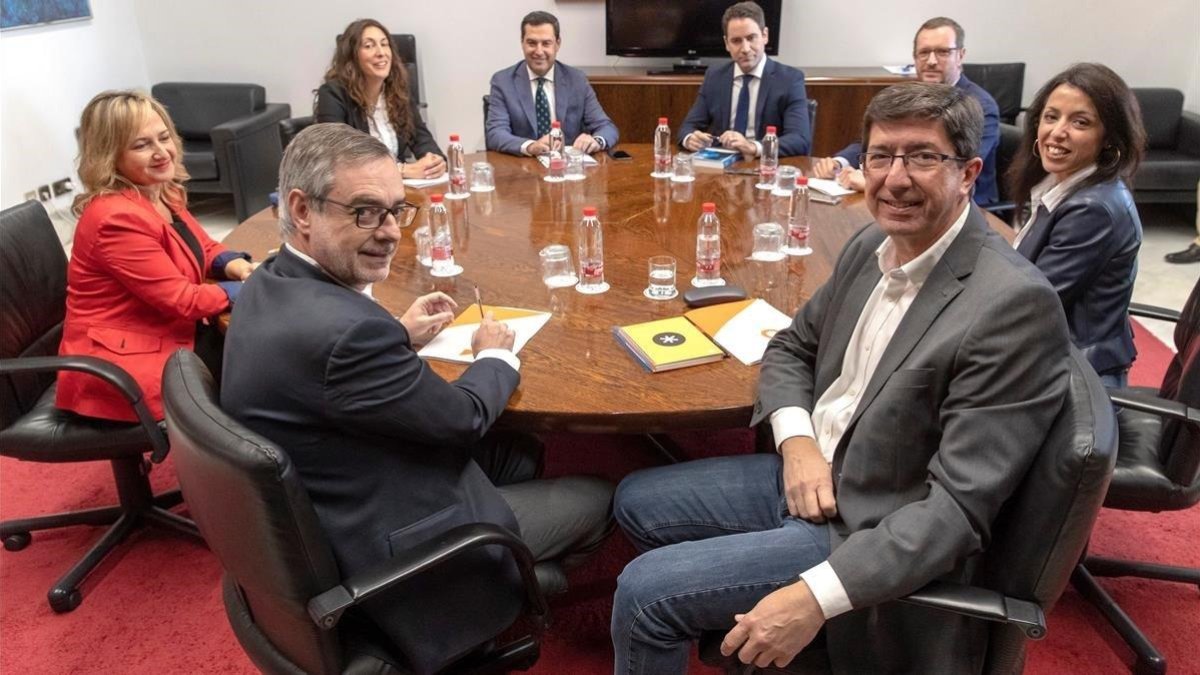 Los equipos negociadores de Partido Popular y Ciudadanos encabezados por Juanma Moreno c y Juan Marin 2d al comienzo de la segunda reunion que mantuvieron el pasado martes en el Parlamento andaluz.-EFE/ JULIO MUÑOZ