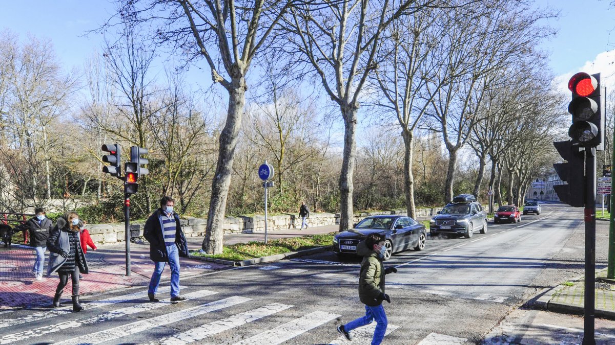 Varios peatones cruzan por el paso de la avenida Palencia, junto a la gasolinera de la Castellana. ISRAEL L. MURILLO
