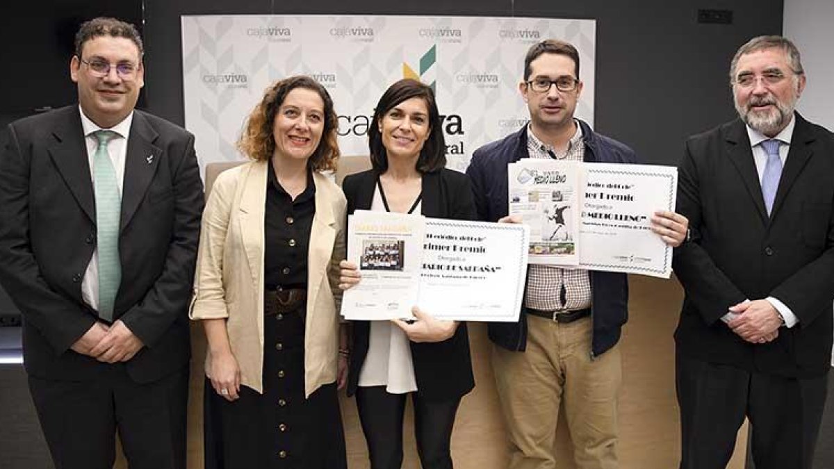 Los representantes de ambos centros recogen los diplomas que los acredita como ganadores así como una edición de su trabajo en papel.-ICAL