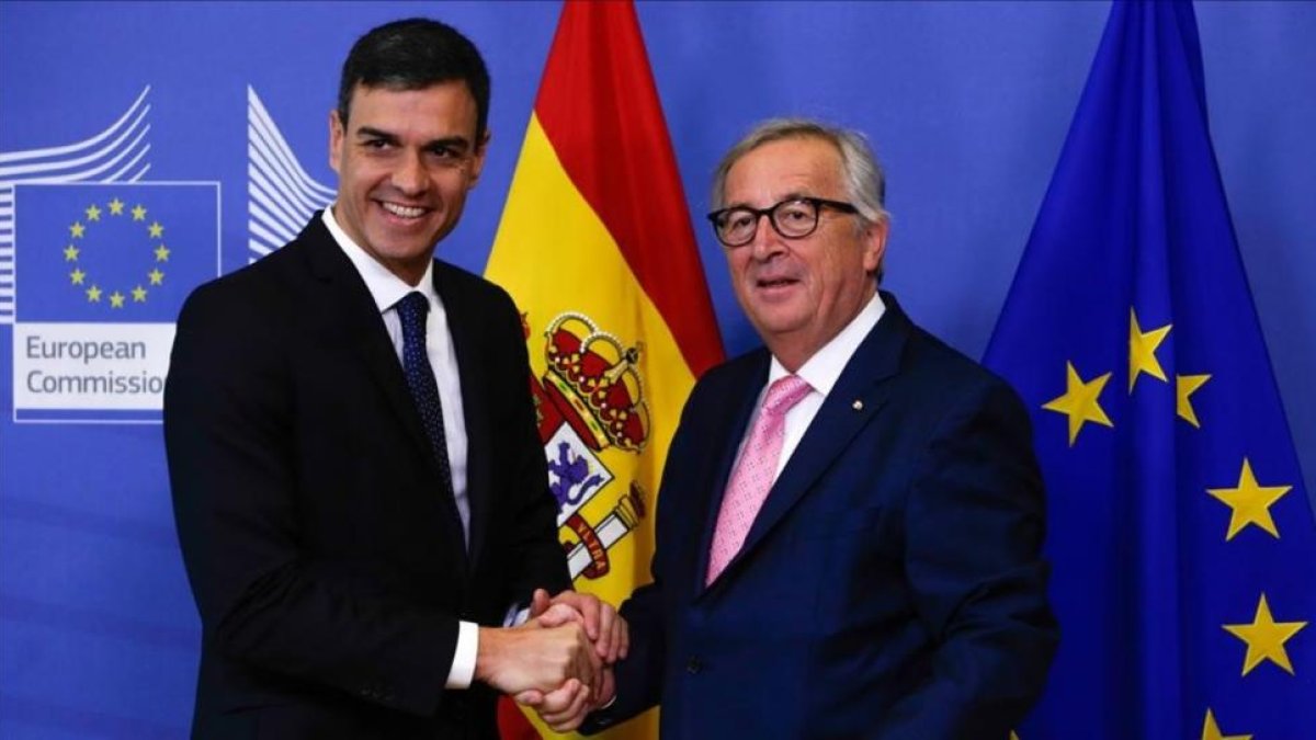 Sánchez y Juncker se saliudan antes de la reunión que han mantenido previa a la cumbre de la UE.-/ ARIS OIKONOMOU (AFP)