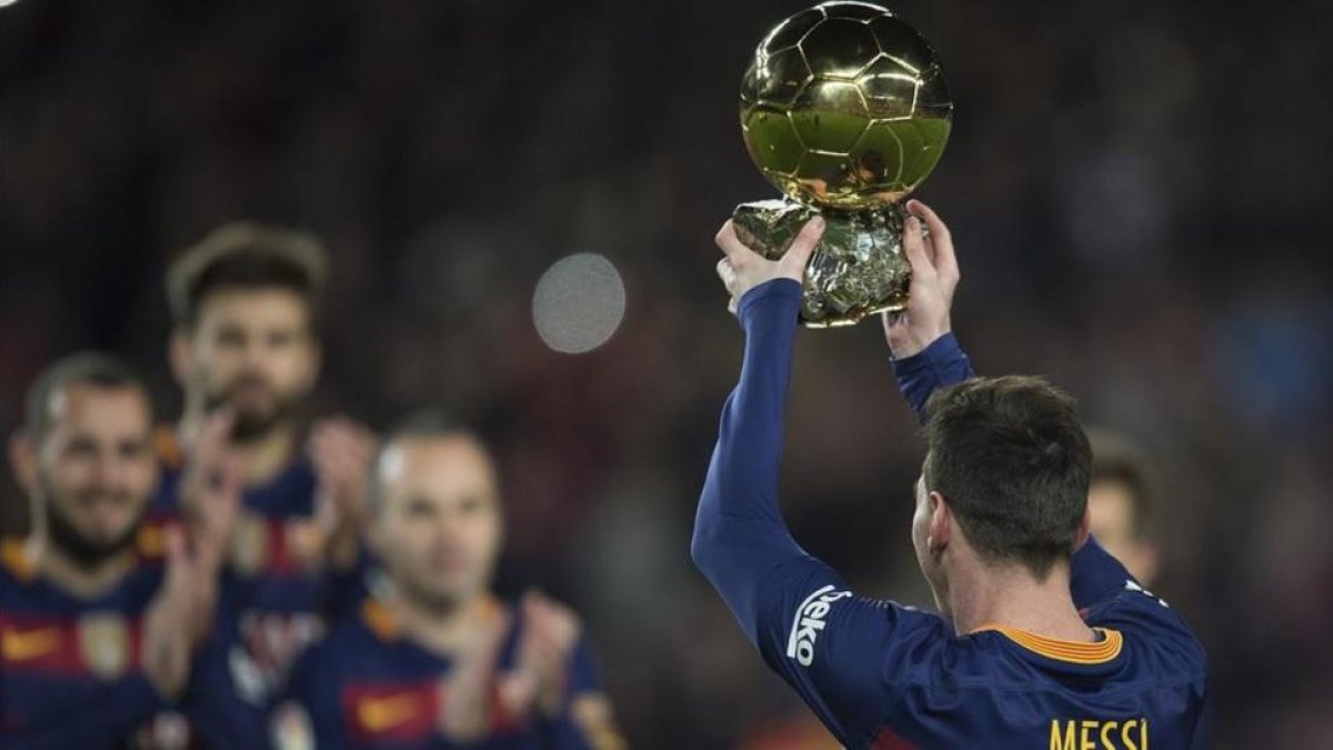 Leo Messi levanta el Balón de Oro del 2015 en el Camp Nou, en enero pasado.-JORDI COTRINA