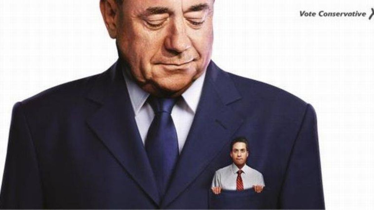 Cartel de los conservadores británicos que muestra a un pequeño Miliband en el bolsillo de Salmond.-