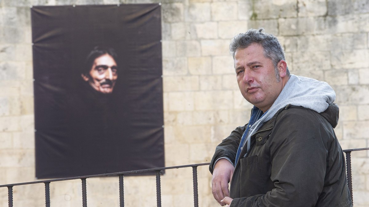 El fotógrafo David Palacín posa junto a uno de los 16 retraros de gran formato que ha realizado para esta muestra urbana. ISRAEL L. MURILLO