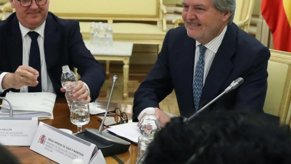 El ministro de Educación, Íñigo Méndez de Vigo, con el cartel que le presenta también como conseller de Ensenyament de Catalunya en la Conferencia Sectorial.-/ BALLESTEROS / EFE