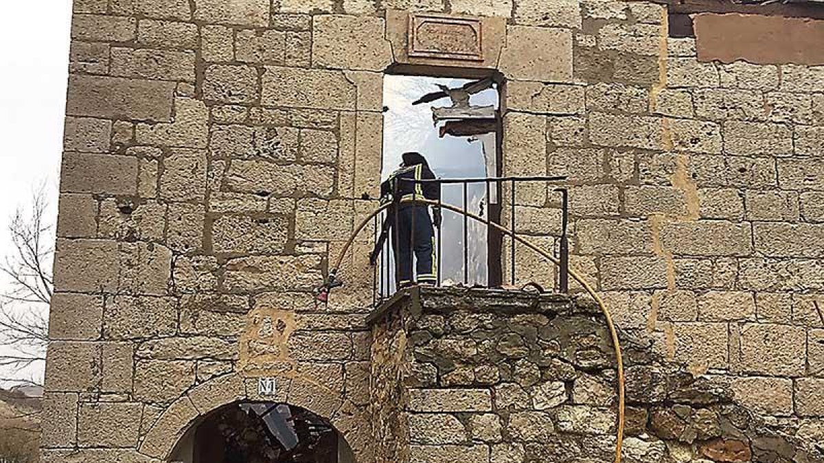 Un bombero supervisa la estructura de la iglesia tras el incendio del año pasado.-Archiburgos