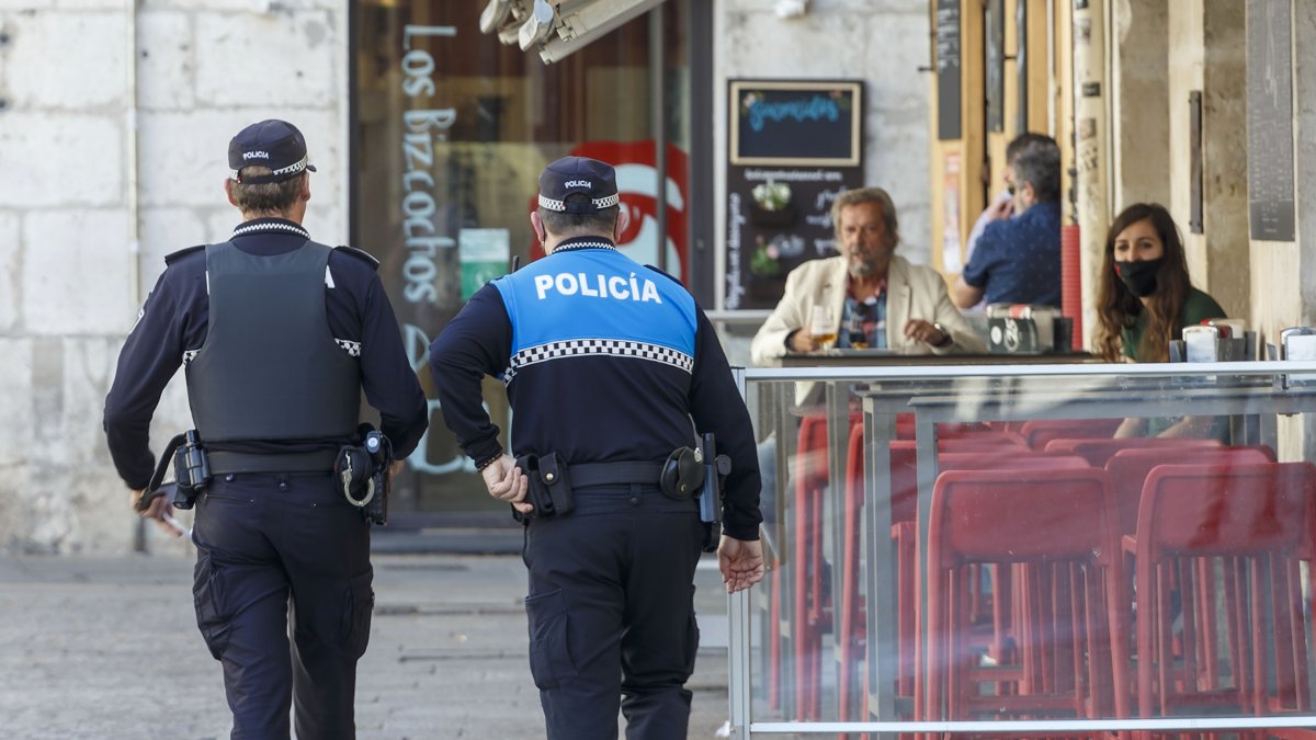 Imagen de dos policías locales junto a un establecimiento de hostelería. SANTI OTERO