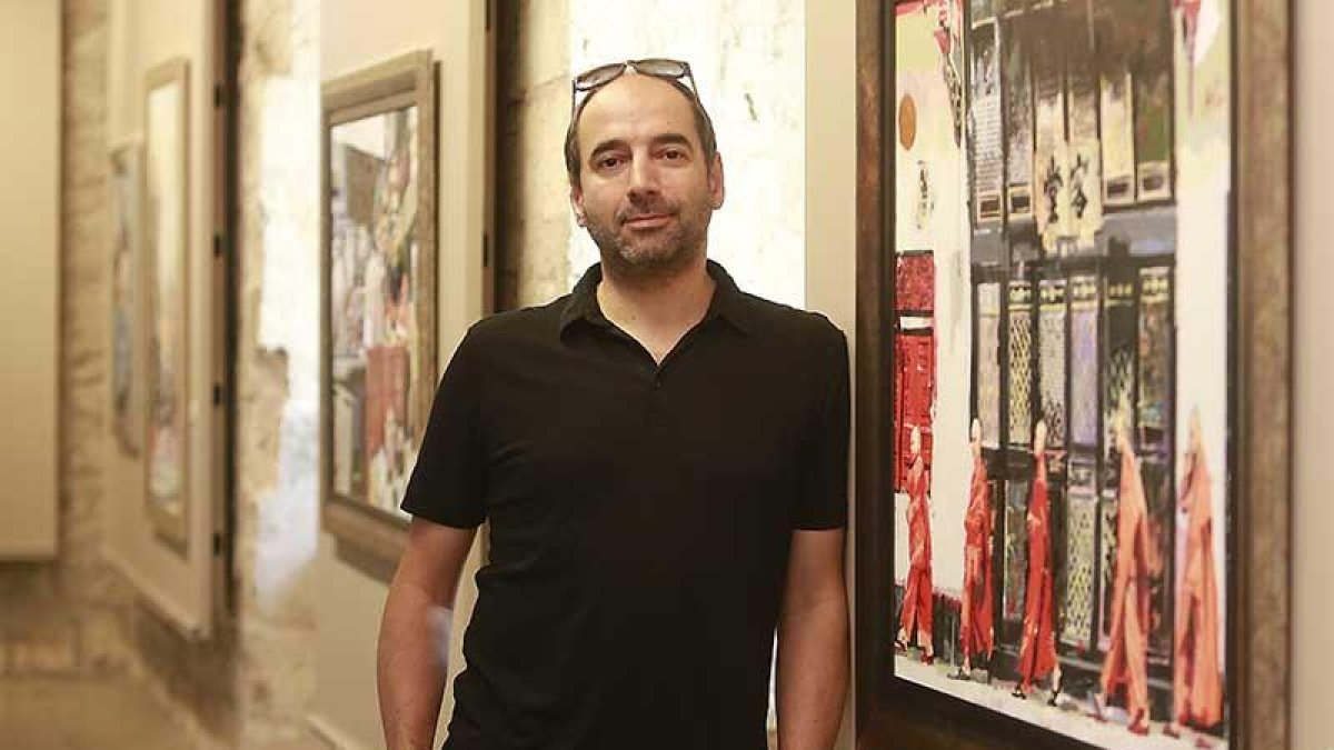 Ismael Alí de Unzaga posa junto a una de las pinturas realizadas a partir de un viaje a Tailandia que recoge a una fila de monjes a la salida de un templo en Bangkok.-Raúl Ochoa