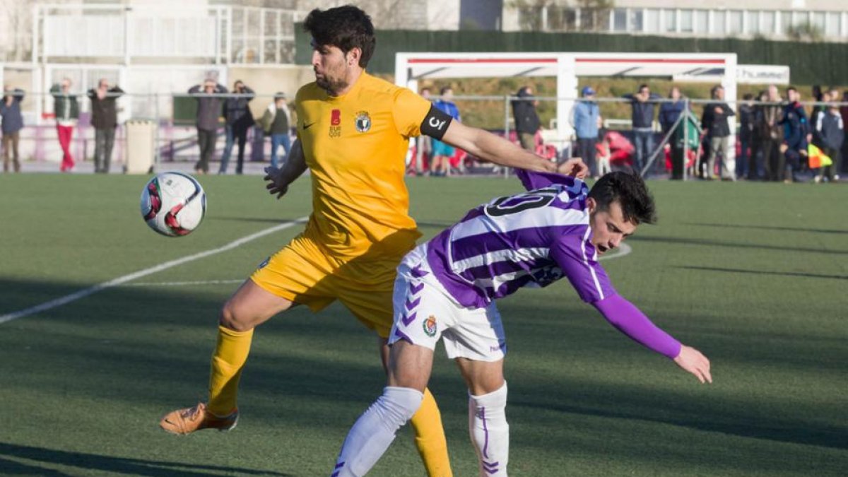 Carlos Quesada puga por el esférico con un jugador vallisoletano durante el encuentro de ayer en los anexos de Zorrilla.-PABLO REQUEJO