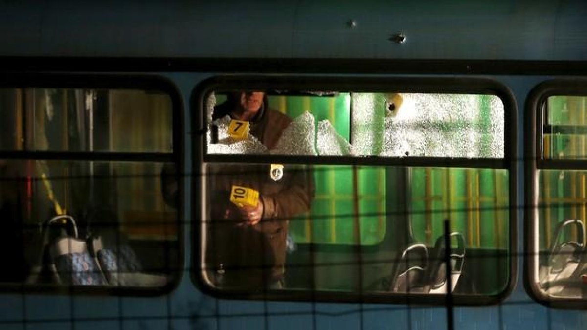 Un forense examina el autobús tiroteado por el agresor, este miércoles en Sarajevo.-REUTERS / DADO RUVIC
