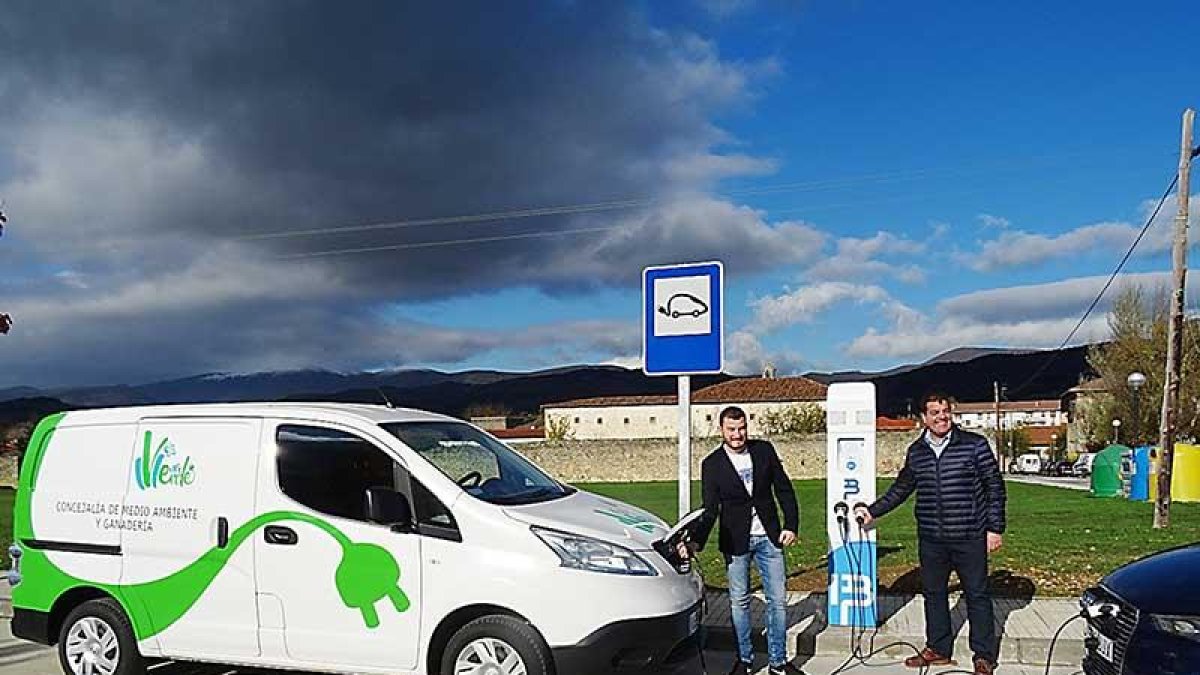 El concejal -centro- realizando la recarga de un vehículo en uno de los dos puntos instalados en la localidad.-ECB