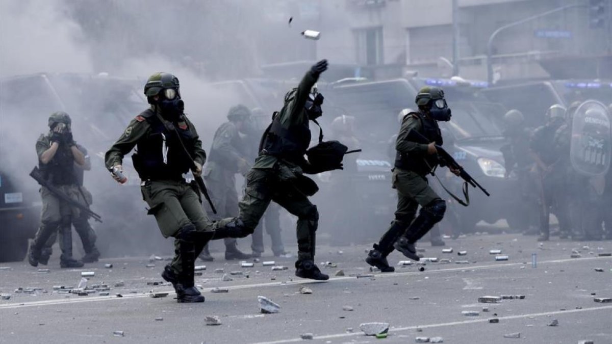 Policías lanzan botes de gas lacrimógeno contra los manifestantes que les lanzaron piedras y latas en las inmediaciones del Congreso, en Buenos Aires, el 14 de diciembre.-AP / NATACHA PISARENKO