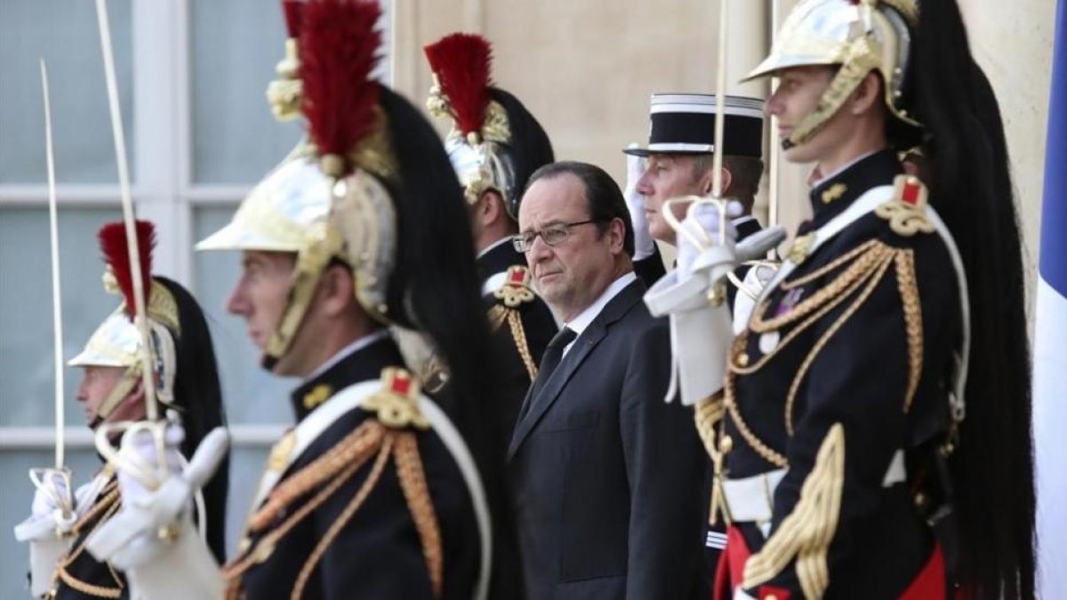 Hollande, rodeado de guardias, mientras espera la llegada del primer ministro finlandés, en el Elíseo, este miércoles.-AP / KAMIL ZIHNIOGLU