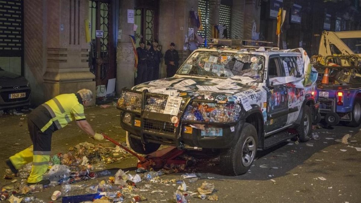 La grúa se lleva los vehículos de la Guardia Civil de la Conselleria de Economia atacados durante la protesta por las detenciones.-FERRAN SENDRA